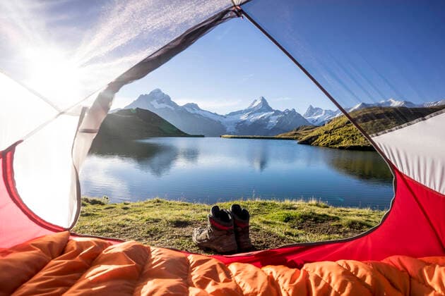 IMAGO Creative: Klimawandel - Nachhaltiges Reisen Tent pitched on shore of Bachalpsee at sunrise MALF00147