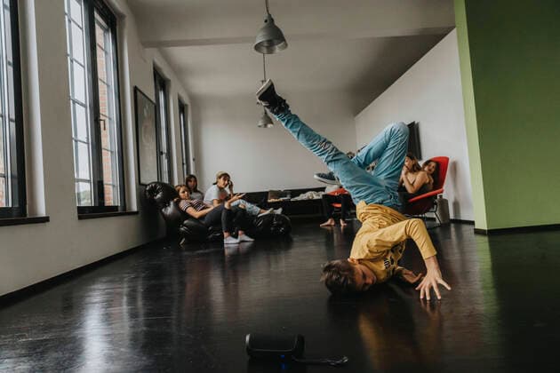 Friends looking at boy breakdancing on floor model released Symbolfoto property released MFF06181