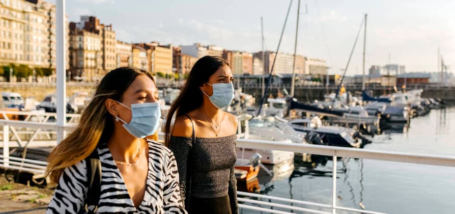 Young women wearing protective face mask in city model released Symbolfoto MGOF04371