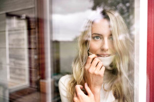 Close-up of businesswoman wearing turtleneck looking through window from office seen through glass model released Symbolfoto property released PESF02070