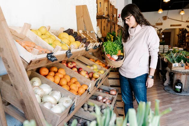 Female customer picking vegetables in basket from grocery store model released Symbolfoto property released RDGF00060