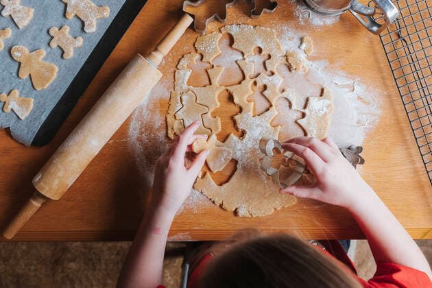 Young girl holding gingerbread dough while sitting at a wooden table Hawera, Taranaki, New Zealand CR_LVBS200923-487917-01 ,model released, Symbolfoto