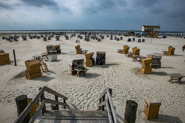 Trotz windigem Herbstwetter sind zahlreiche Menschen am Strand von St Peter Ording um an der Nordsee das Naturschauspiel zu genießen.