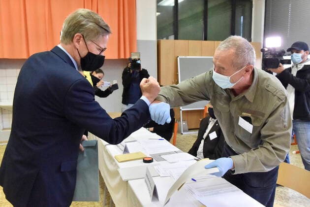 Chairman ODS Petr Fiala, left, and election committee member greet each other with an elbow bump during the regional and Senate elections in Brno, Czech Republic, October 2, 2020. (CTKxPhoto VaclavxSalek) CTKPhotoP202010020786201 sal 06