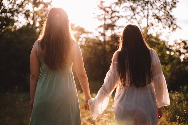 Back view of lesbian couple holding hands while standing in forest CR_DMBE200923-468581-01 ,model released, Symbolfoto