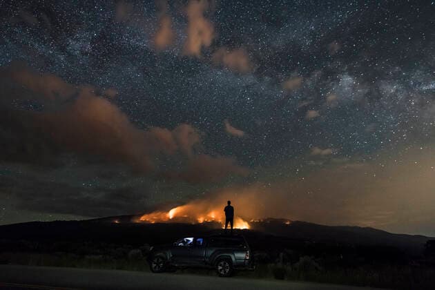 Man looking at wildfire while standing on off-road vehicle against star field Basalt, CO, United States CR_BRHU200930-501991-01 ,model released, Symbolfoto