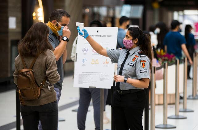 (201006) -- TORONTO, Oct. 6, 2020 -- A security officer wearing a face mask checks the temperature of a customer outside an Apple store in Toronto, Canada, on Oct. 6, 2020. Canada s daily cases of COVID-19 continued to increase. As of Tuesday afternoon, the country reported a total of 170,945 cases of COVID-19, including 9,527 deaths, according to CTV. (Photo by Xinhua) CANADA-TORONTO-COVID-19-CASES ZouxZheng