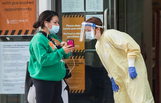 (201006) -- TORONTO, Oct. 6, 2020 -- A medical worker wearing protective gear checks appointment information of a woman at a COVID-19 assessment center in Toronto, Canada, on Oct. 6, 2020. Canada s daily cases of COVID-19 continued to increase. As of Tuesday afternoon, the country reported a total of 170,945 cases of COVID-19, including 9,527 deaths, according to CTV. (Photo by Xinhua) CANADA-TORONTO-COVID-19-CASES ZouxZheng