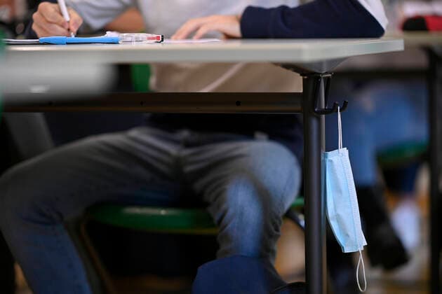 Mundschutzmaske hängt an Schütertisch, Präsenzunterricht, Corona-Krise, Stuttgart, Baden-Württemberg, Deutschland Coronavirus