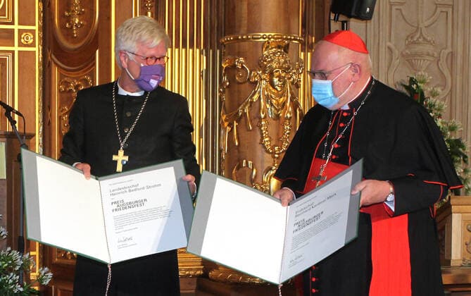 Der Ratsvorsitzender der Evangelischen Kirche in Deutschland (EKD), Heinrich Bedford-Strohm (li.), und der Muenchner Erzbischof Kardinal Reinhard Marx (re.) haben den Augsburger Friedenspreis erhalten. Beim Festakt am Samstagabend (10.10.2020) im Goldenen Saal des Rathauses in Augsburg sagte als Laudator der fruehere Bundespraesident Joachim Gauck, dass die beiden Kirchenmaenner Vorbilder oekumenischer Verstaendigung seien. Bedford-Strohm und Marx seien durch die christlichen Werte von Solidaritaet, Gerechtigkeit und Hoffnung ueber konfessionelle Unterschiede hinweg miteinander verbunden. Der mit 12.500 Euro dotierte Friedenspreis wird seit 1985 von der Stadt Augsburg und der bayerischen Landeskirche alle drei Jahre fuer Verdienste um ein Copyright: epd-bild AnnettexZoepf EDITORIAL USE ONLY