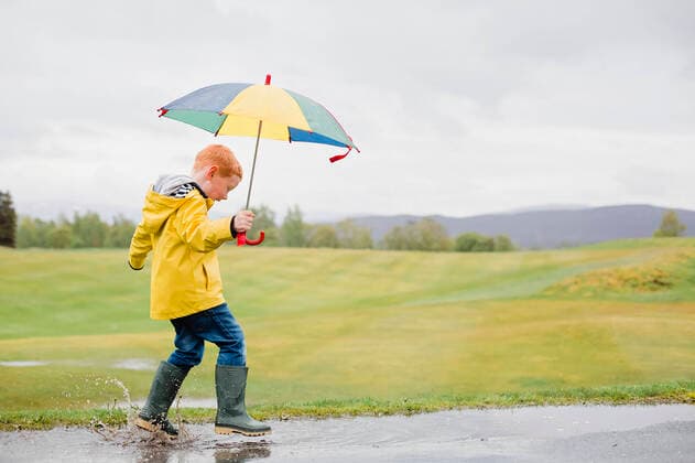 Creative Highlights Symbolfotos Redheaded little boy with umbrella playing in the rain model released Symbolfoto NMS00298