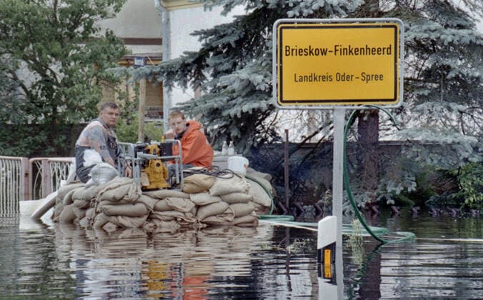 Oderflut 1997 Brieskow-Finkenheerd, DEU, Juli 97 - Anwohner eines überfluteten Hauses sitzen auf Sandsaecken. Brieskow-Finkenheerd Germany