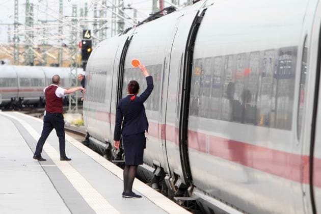 Zugbegleiter der DB Deutsche n Bahn AG signalisieren dem aus dem Fenster schauenden Lokführer mit einer roten Kelle die Abfahrt eines ICE im Hauptbahnhof Leipzig, Sachsen, Deutschland *** DB Deutsche n Bahn AG train attendants signal the departure of an ICE train at Leipzig Central Station, Saxony, Germany, to the driver looking out of the window with a red trowel