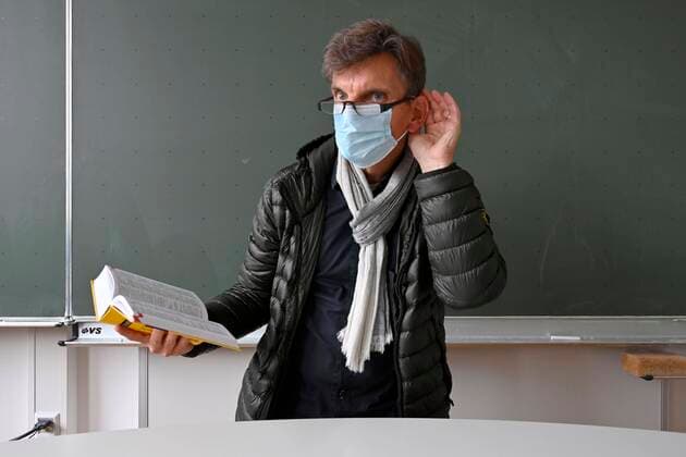 Lehrer mit dicker Winterjacke, Schal und Mundschutzmaske im Präsenzunterricht, Hand am Ohr, Verständigungsprobleme, Corona-Krise, Stuttgart, Baden-Württemberg, Deutschland, Europa Copyright: imageBROKER/MichaelxWeber iblimw05902325.jpg