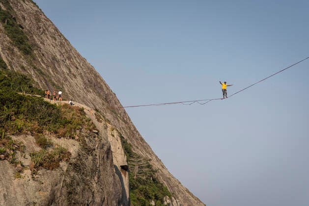 IMAGO Creative: Sport Dichotomien - Land und Wasser Beautiful view to highliner walking the line on rocky ocean shore Niterói, RJ, Brazil CR_GNUJ201020-521598-01 ,model released, Symbolfoto