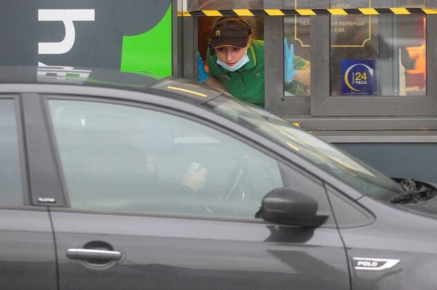 KAZAN, RUSSIA - OCTOBER 24, 2020: An employee is seen in a McDonald s drive-through window in Gorky Park amid the COVID-19 pandemic. Yegor Aleyev TASS  TS0EBEC6