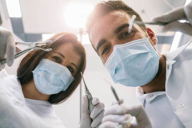 Male dentist and female assistant with medical instruments during treatment in clinic model released Symbolfoto property released ABZF03397