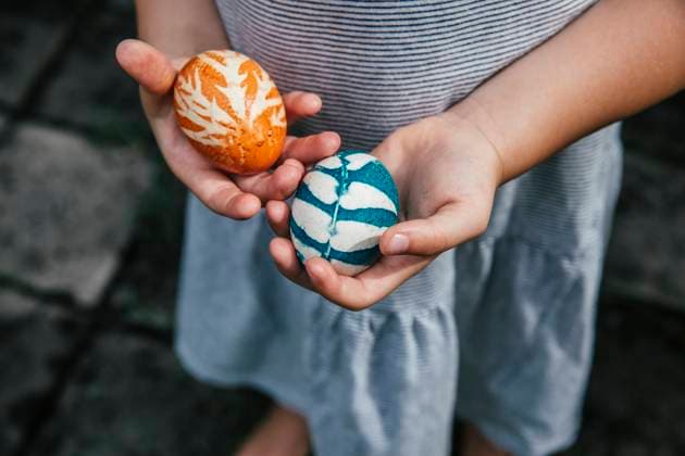 Hands of baby girl holding organically colored Easter eggs model released Symbolfoto MBEF01465