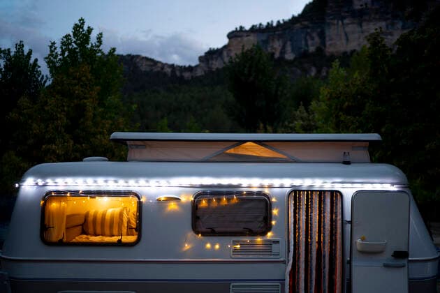 IMAGO Creative: Klimawandel - Nachhaltiges Reisen Illuminated motor home against mountain at dusk OCMF01728