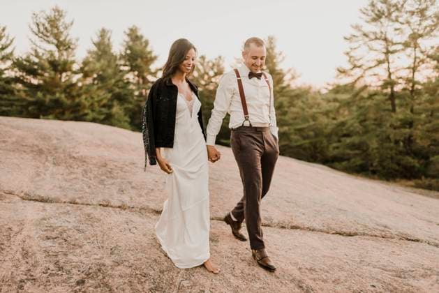 Couple walking on walkway while holding hands in forest during sunset model released Symbolfoto SMSF00366