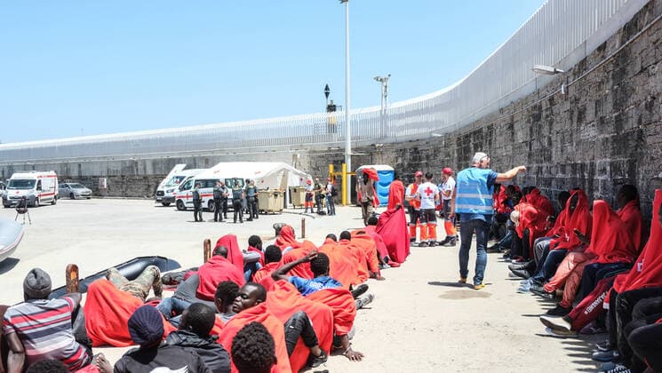 Aus dem Mittelmeer gerettete Migranten und Flüchtlinge sitzen und stehen am 24. Juli 2018 im Hafen von Tarifa, Spanien. Täglich kommen im Sommer 2018 Hunderte Bootsflüchtlinge aus Marokko in die Europäische Union. Tarifa Spanien