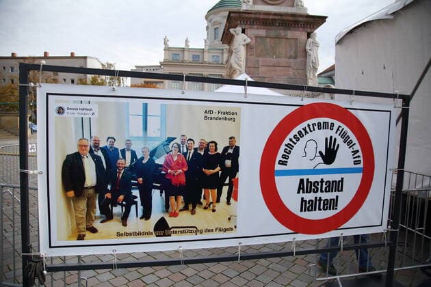 Ein Banner mit einem Gruppenfoto der AfD-Fraktion und der Aufschrift Rechtsextreme Flügel-AfD Abstand halten! bei einem Protestkonzert gegen die Wahl des neuen AfD-Fraktionsvorsitzenden auf dem Alten Markt am Brandenburger Landtag in Potsdam, 27. Oktober 2020. Protestkonzert Flügel statt Flügel in Potsdam