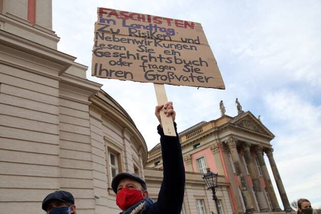 Ein Mann mit einem Plakat Faschisten im Landtag Zu Risiken und Nebenwirkungen lesen Sie ein Geschichtsbuch oder fragen Sie Ihren Großvater bei einem Protestkonzert gegen die Wahl des neuen AfD-Fraktionsvorsitzenden auf dem Alten Markt am Brandenburger Landtag in Potsdam, 27. Oktober 2020. Protestkonzert Flügel statt Flügel in Potsdam
