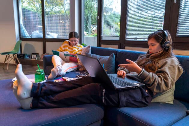 Homeschooling, 2 Mädchen, Schwestern, 11 Jahre alt, lernen Zuhause, Home learning, Unterricht in der Wohnung, Fernunterricht, Chat mit Lehrern und Mitschülern über den Laptop, Tablet-PC, Symbolbild, Homeschooling