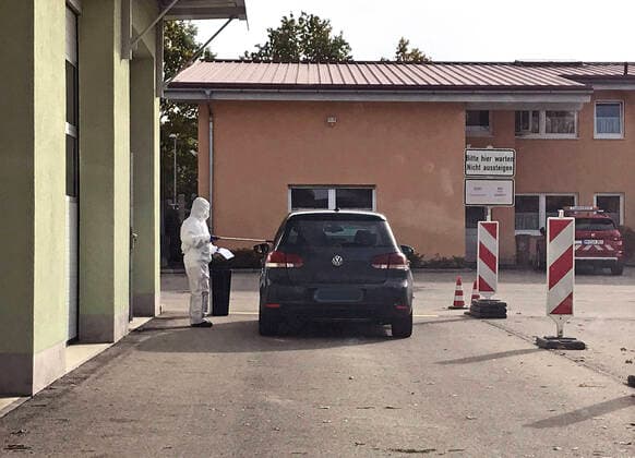 30.10.2020, Corona-Teststation in Mindelheim auf dem Kreisbauhof. Ein Mitarbeiter im Ganzkörper-Schutzanzug reicht einem Autofahrer das Teststäbchen durch das offene Fenster. 30.10.2020, Corona-Teststation Mindelheim 30.10.2020, Corona-Teststation Mindelheim