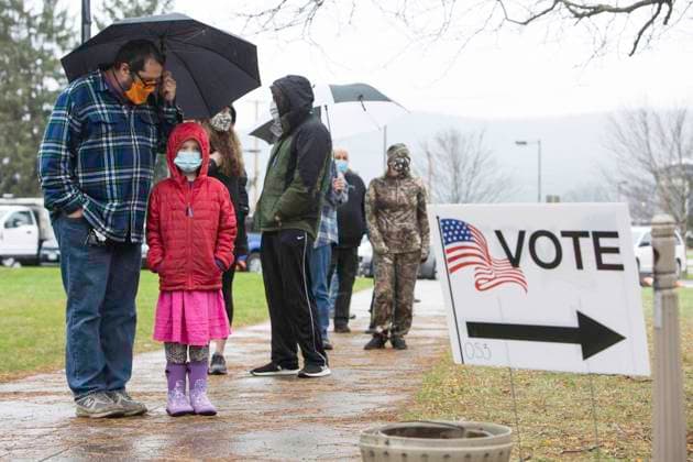November 1, 2020, Cooperstown, NY, U.S: Charles Cotton of Cooperstown, NY, with his daughter Ruby, age 7, and other voters in Otsego County, NY, wait in the rain outside the county board of elections office to cast their ballot for President on New Yorks last day of early voting, November 1, 2020. In the county, more than twice as many people voted early compared to 2016 N 5,137 voters had voted early as of 1 p.m. Sunday, compared to 2,410 early and absentee voters in 2016, according to county election officials... : .Date: 11 1 2020.File : 20-C27606 Cooperstown U.S. - ZUMAmr6_ 20201101_zap_mr6_002 Copyright: xMichaelxForsterxRothbartx
