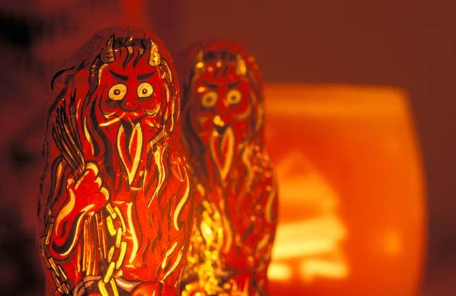 Schokolade Krampus vor roter Kerze Austria *** Chocolate Krampus in front of red candle Austria 