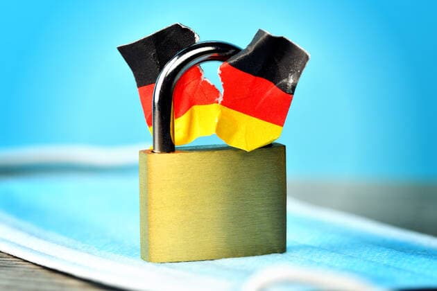 Geschlossenes VorhÃ¤ngeschloss mit angerissener Deutschlandfahne, Spaltung der Gesellschaft durch den Lockdown