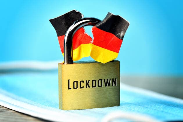 FOTOMONTAGE, Geschlossenes VorhÃ¤ngeschloss mit angerissener Deutschlandfahne und Aufschrift Lockdown, Spaltung der Gesellschaft durch den Lockdown