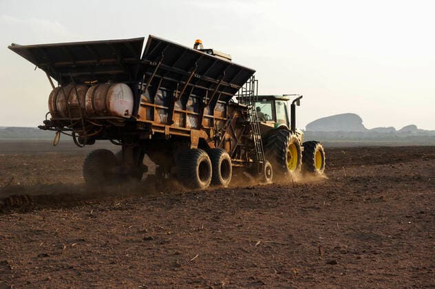 ANGOLA Malange Biocom project for sugar production ANGOLA Malange , Biocom Project of Odebrecht Brazil and oil company Sonangol, sugar factory and large farm for production of sugar cane for 240.000 tons sugar and 30 billion litre bio ethanol, John Deere tractor with planting machine *** ANGOLA Malange , Biocom Projekt, Joint venture zwischen Konzern Odebrecht aus Brasilien und Sonangol, staatliche Oelgesellschaft Angolas, und weiteren Investoren u.a. Isabel dos Santos, Tochter des Praesidenten Dos Santos, auf einigen tausend Hektar wird Zuckerrohr fuer Produktion von Zucker und Bioethanol angebaut, die Zuckerfabrik ist im Bau und soll 240.000 Tonnen Zucker pro Jahr herstellen, dazu kommen 30 Millionen Liter Ethanol und 70 Megwatt Strom aus