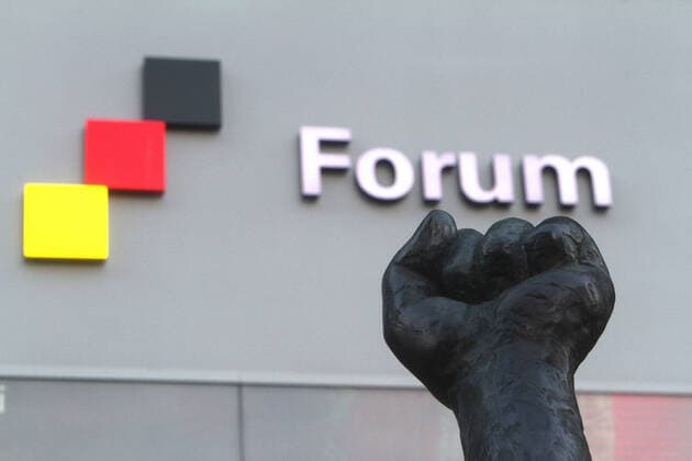 Die Faust einer Skulptur mit Flagge der Bundesrepublik und Schriftzug Forum vor dem Eingang zum Zeitgeschichtlichen Forum in Leipzig, Sachsen, Deutschland