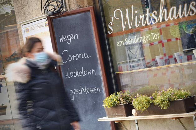Themenbild: Coronavirus Pandemie Folgen fuer die Gastronomie. Schild am Wirtshaus am Sendlinger Tor; WEGEN CORONA LOCKDOWN GESCHLOSSEN, eine junge Frau,Passantin geht vorbei. Geschlossenes bayerisches Restaurant am Sendlinger Tor in Muenchen. Seit dem 2.November muss wegen dem Lockdown light die Gastronomie geschlossen bleiben, Schliessung-Folge der Corona Pandemie,Lockdown,Shutdown,Inzidenzwert. MODEL RELEASED!