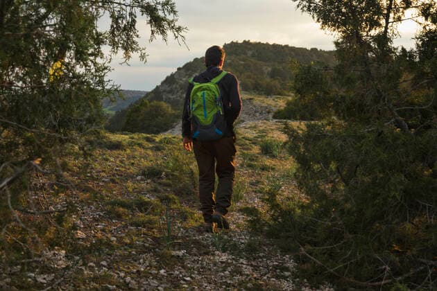IMAGO Creative: Sommer, Abendspaziergang Man walking in the mountain surrounded by trees at sunset Spain, Castile and León, Burgos CR_MKTJQK201102D-545400-01 ,model released, Symbolfoto