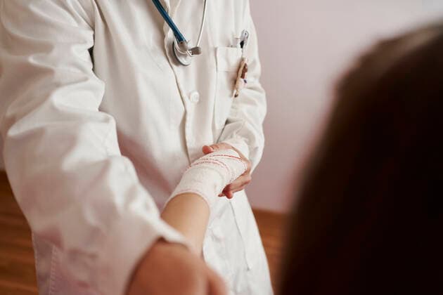 side view of a female doctor bandaging the arm of a little girl in her room. Home doctor concept Pamplona, Navarre, Spain CR_SEBO201112B-549761-01 ,model released, Symbolfoto ,property released