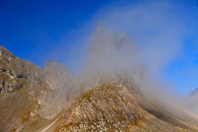 Berg Eystrahorn mit blauem Himmel und einer Nebelwolke, Island, Ostisland, Krossanesfjall, Eystrahorn mountain Eystrahorn with blue sky and a cloud of fog, Iceland, East Iceland, Krossanesfjall, Eystrahorn BLWS632489