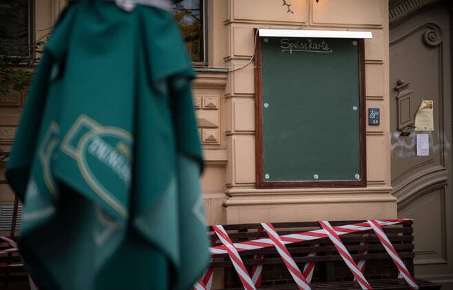 Ein Absperrband über Sitzgelegenheiten vor einem Gastronomiebetrieb mit leerer Speisekarte in Berlin Prenzlauer Berg. Foto: bildgehege Gastronomie im Lockdown