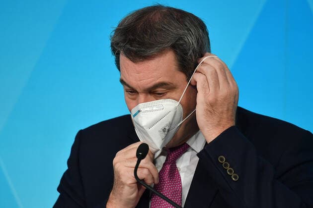 Markus SOEDER (Ministerpraesident Bayern und CSU Vorsitzender) zieht seine ffp2,KN95 Maske auf,Mundschutz,Maske, Einzelbild,angeschnittenes Einzelmotiv,Portraet,Portrait,Porträt. Pressekonferenz der Bayerischen Staatsregierung- zum Thema Corona Pandemie und dem Lockdown Light,Wellenbrecher am 18.11.2020 im Prinz Carl Palais in Muenchen.