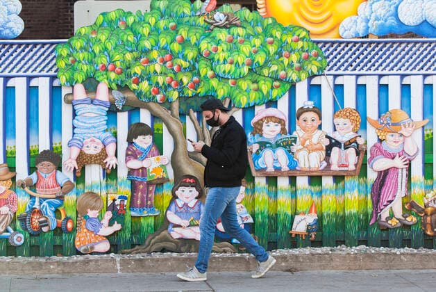 (201120) -- TORONTO, Nov. 20, 2020 -- A man wearing a face mask walks past a decorated fence in Toronto, Canada, on Nov. 20, 2020. Canadian Prime Minister Justin Trudeau said on Friday that the country is at stake as COVID-19 has been worsening. As of Friday afternoon, Canada reported a total of 319,038 cases and 11,313 deaths. (Photo by Xinhua) CANADA-TORONTO-COVID-19-CASES ZouxZheng 