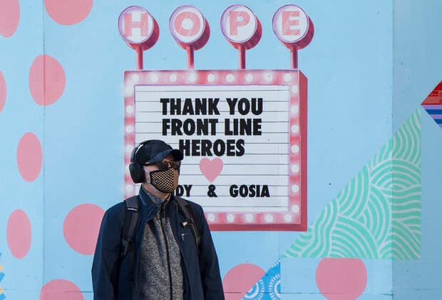 (201120) -- TORONTO, Nov. 20, 2020 -- A man wearing a face mask walks past a mural thanking frontline workers in Toronto, Canada, on Nov. 20, 2020. Canadian Prime Minister Justin Trudeau said on Friday that the country is at stake as COVID-19 has been worsening. As of Friday afternoon, Canada reported a total of 319,038 cases and 11,313 deaths. (Photo by Xinhua) CANADA-TORONTO-COVID-19-CASES ZouxZheng 