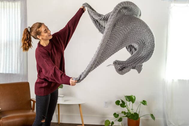 IMAGO Creative: Frühjahrsputz Woman Gets Ready To Fold Blanket United States, California, Los Angeles CR_JABUWS201119-550927-01 ,model released, Symbolfoto