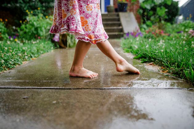 close-up of a small barefoot child dancing on front stoop in the rain Columbus, OH, United States CR_RETI201122A-497522-01 ,model released, Symbolfoto
