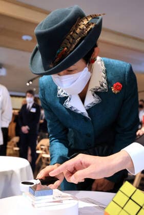 November 24, 2020, Tokyo, Japan - Japanese Princess Takamado admires a 9.9mm cubu allow made Lubik s Cube witha magnifier at a reception for the 40th anniversary of Lubik s Cube puzzle in Tokyo on Tuesday, November 24, 2020. Japanese artists produced art works for the anniversary of Lubik s Cube Lubik s Cube Inspiration Project and the embassy will have auction for charity.  (148755628)