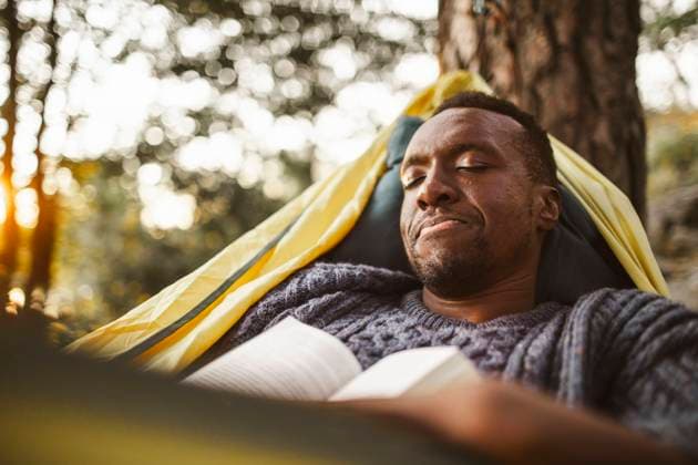 IMAGO Creative: Frühlingsferien und reisen Man with book sleeping in hammock at forest, MA82611, Sweden, Stockholm, model released