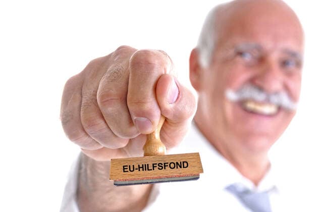 alter Mann haelt einen Stempel in der Hand, mit der Aufschrift EU-Hilfsfond, Deutschland old man with stamp in his hand lettering EU-Hilfsfond EU aid fund, Germany BLWS633737