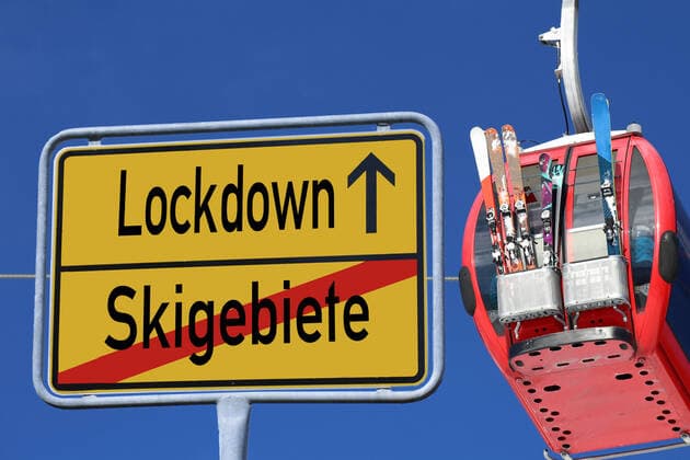 Symbolbild geschlossene Skigebiete: Ortsausgangsschild mit Skipiste im Hintergrund. Kanzlerin Merkel will wegen der Corona-Krise die Skigebiete in Europa geschlossen halten - stößt aber auf Widerstand aus Österreich und der Schweiz.Im Bildhintergrund eine Gondel der Schönjochbahn im Skigebiet Serfaus, Fiss, Ladis (Tirol, Österreich)