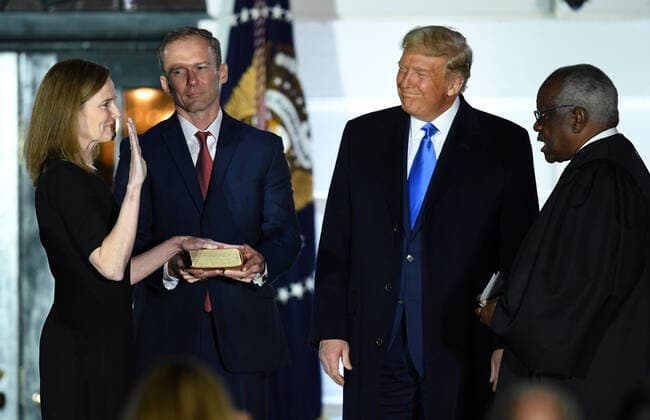 Judge Amy Coney Barrett takes her Constitutional oath administered by Supreme Court Justice Clarence Thomas as her husband Jesse Barrett and President Donald Trump watch, during a ceremony at the White House in Washington, DC, on Monday, October 26, 2020. The Senate confirmed Barrett, 52-48, to be the next Supreme Court Justice, replacing the late Ruth Bader Ginsburg.  POY2020DC185 KEVINxDIETSCH